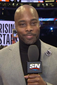 Alvin Williams in a grey jacket holding a Sportsnet microphone.