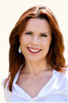 Annie Duke in a white shirt, smiling.