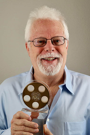 Foley Artist John Roesch holding one of his golden reel awards.