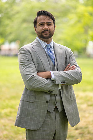 Cyber Security Expert Prashanth Challa in a grey jacket and blue shirt with his arms folded.