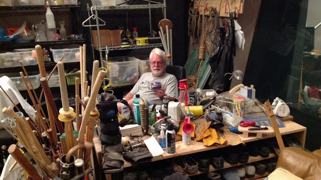 Foley Artist John Roesh sitting behind his desk surrounded by instruments