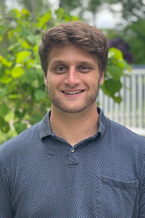 Luke Marturana in a blue shirt, smiling, standing outdoors