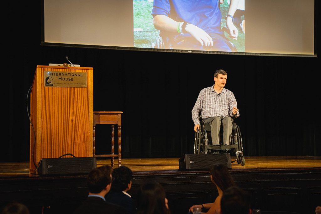 Keynote Speaker Robert Paylor on stage, in his wheel chair. 