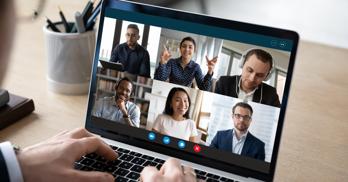 hands on laptop displaying a virtual meeting with six people