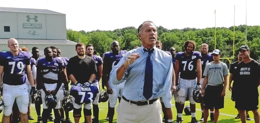 Kevin Reilly Surrounded by Football Players