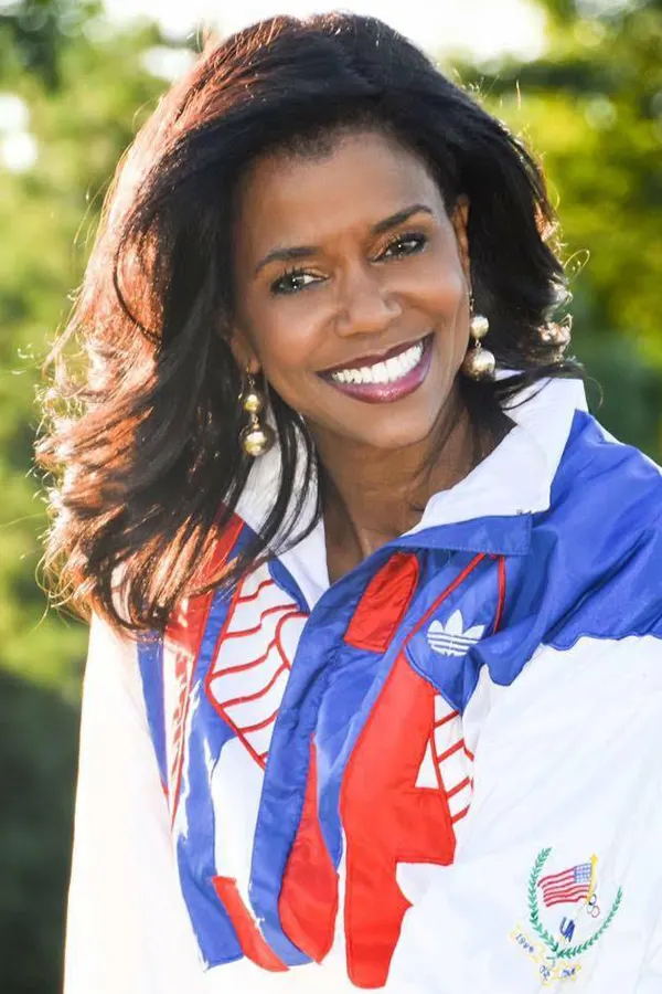 U.S. Olympian and Keynote Speaker Leslie Maxie wearing an olympic jacket and smiling