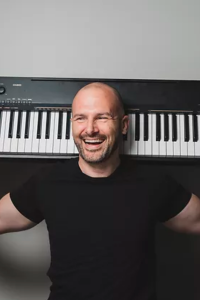 Gregory Offner, a keynote speaker, musician, and entertainer, poses with his keyboard.