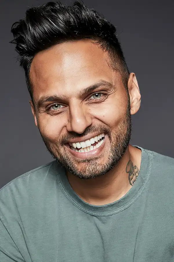 Keynote Speaker Jay Shetty in a green-grey t-shirt, smiling.