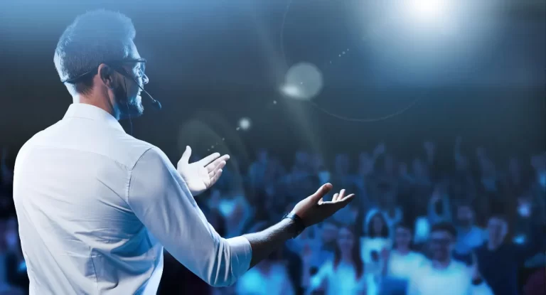 A man performing on stage, facing an audience