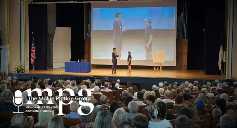 David Kwong is on stage performing a trick with a child.