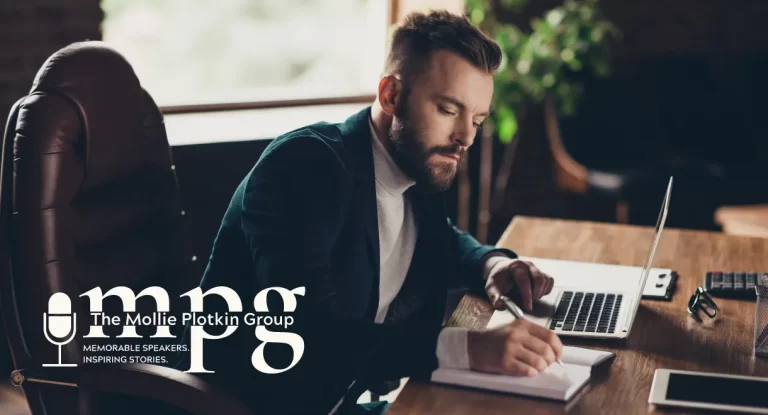 Executive leadership coach sitting at a desk taking notes.